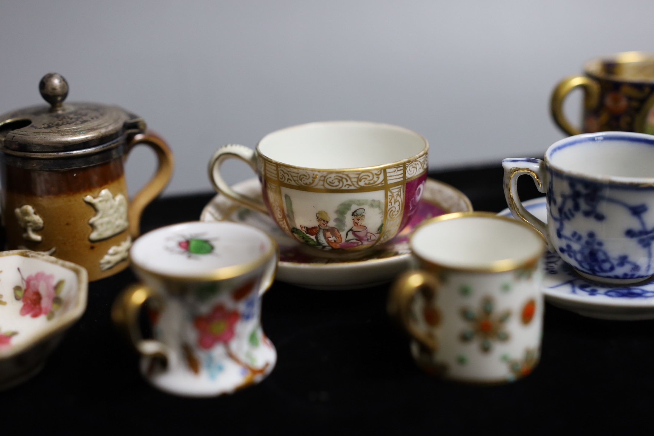 Miniatures: A Spode type Hydra jug and basin painted with flowers, a Crown Staffordshire two handled mug with flowers on a gilded blue ground, two continental cups and saucer one with Watteauesque scenes, the other in bl